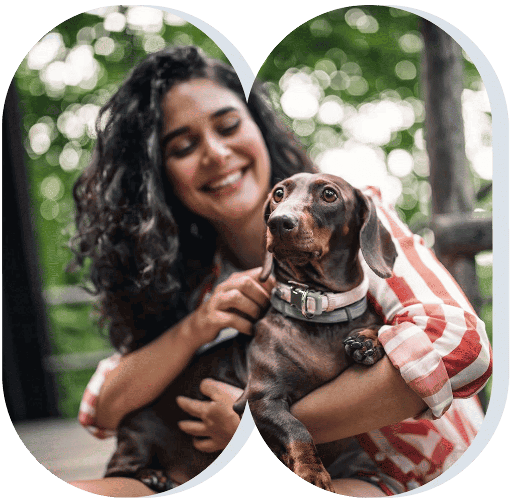 A happy dog owner holding her small brown dog